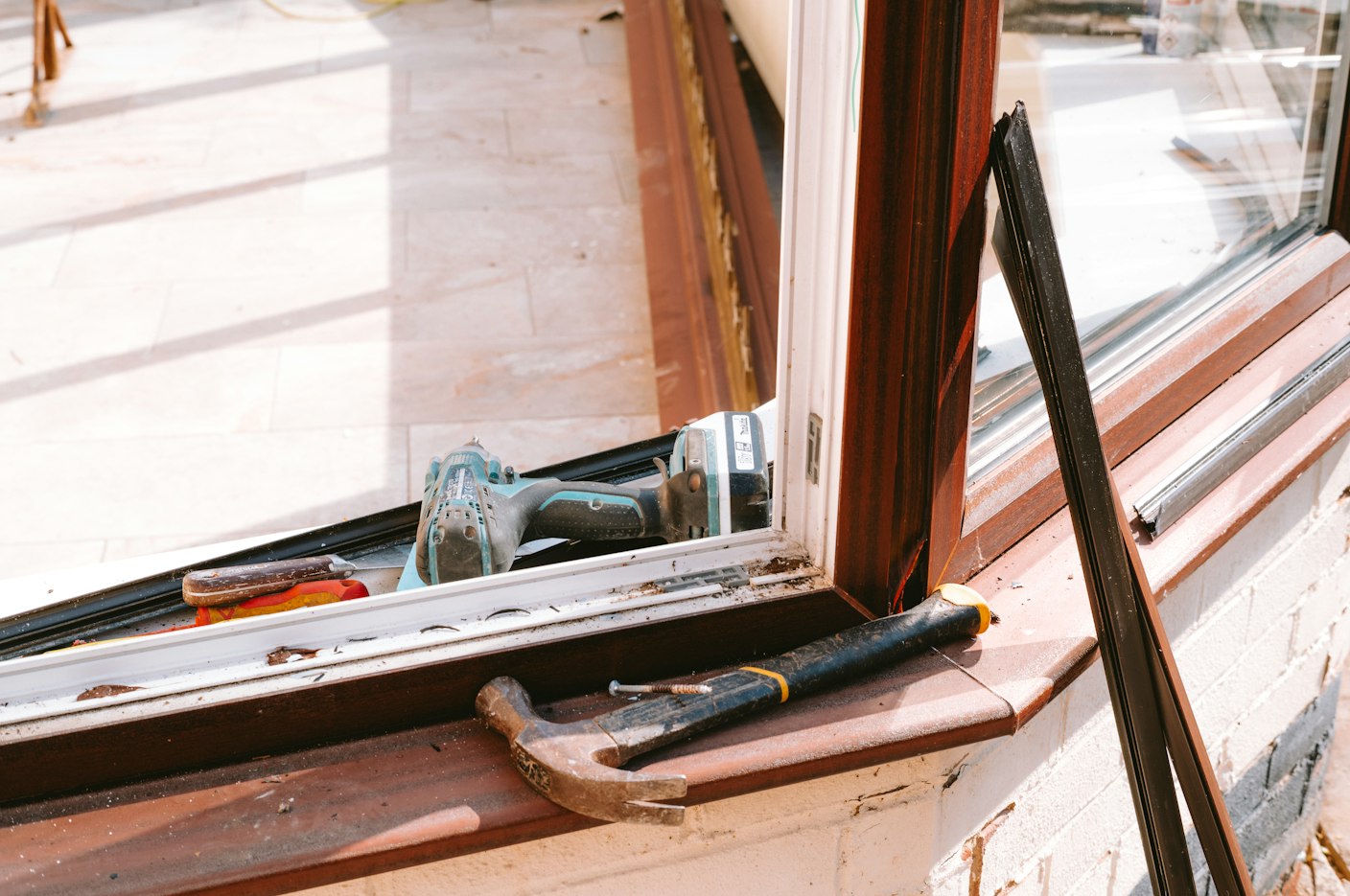 Hammer and drill on a windowsill during a repair